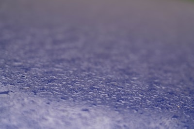 Close-up of a water droplet beading on a treated paper surface.