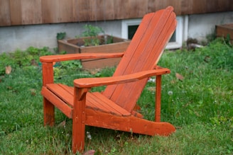 A vibrant plastic outdoor Adirondack chair set against a sunny garden backdrop, inviting relaxation.
