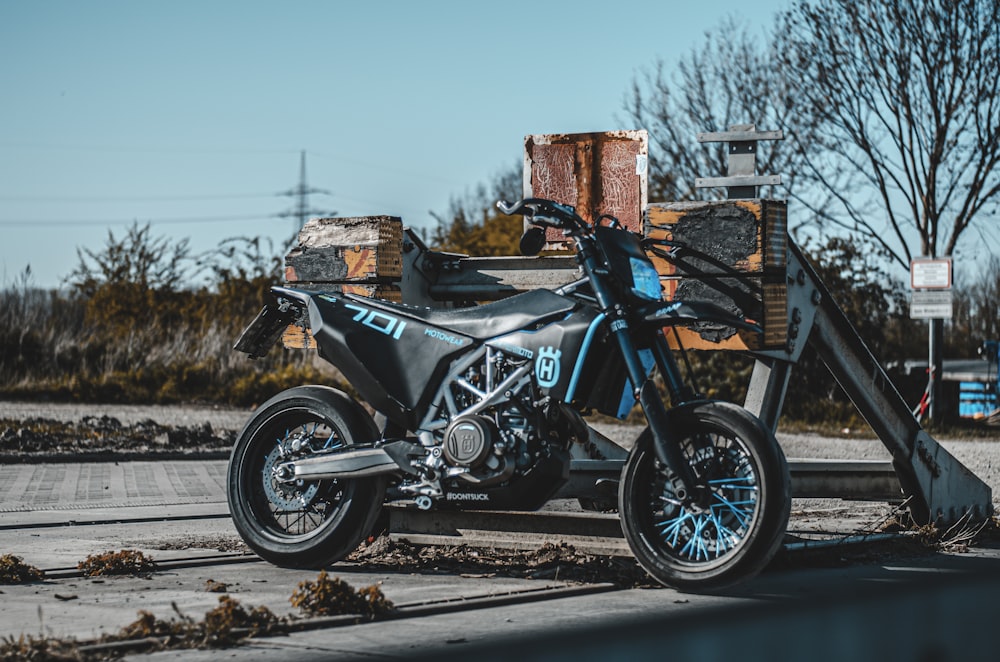 black and blue motorcycle parked on gray concrete road during daytime