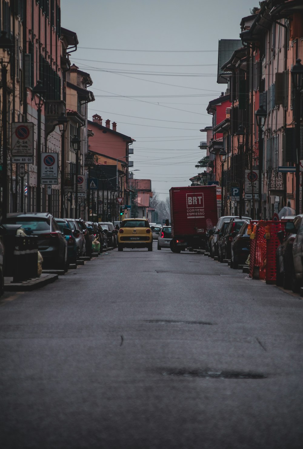 cars parked on street between buildings during daytime