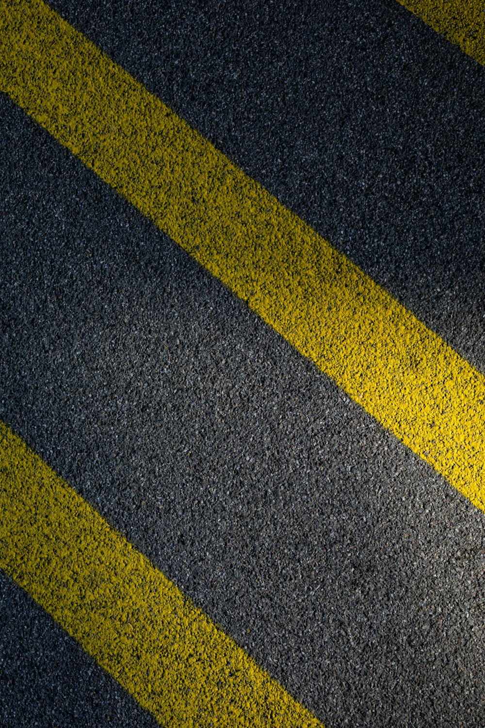 Ligne noire et jaune sur chaussée en béton gris