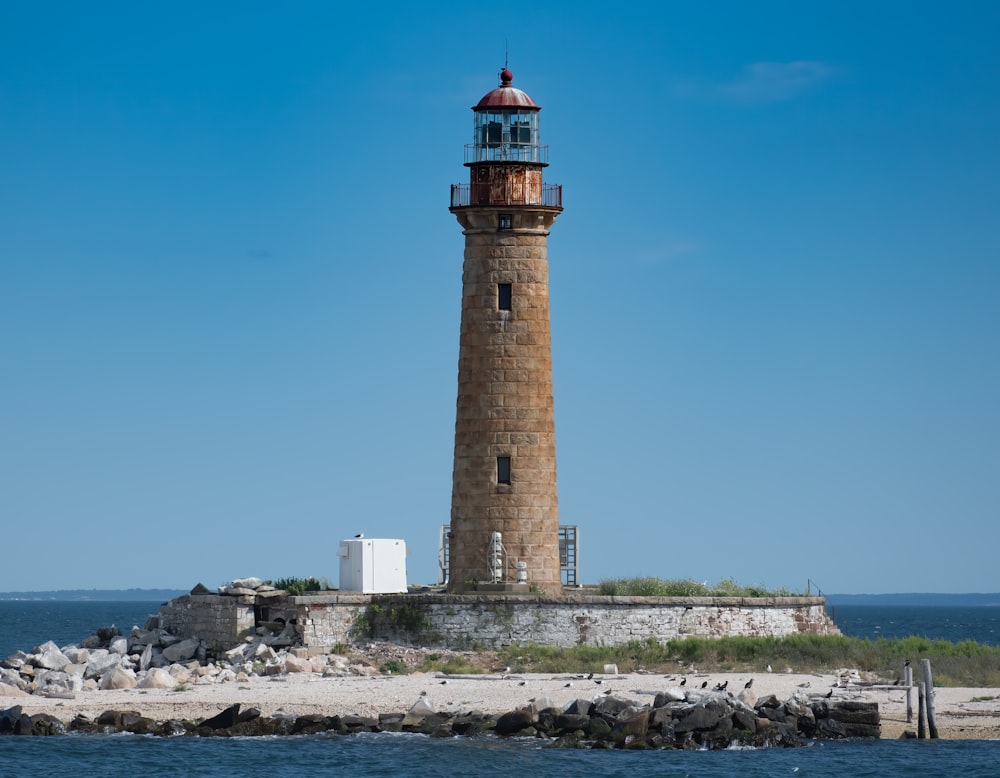 brown and white lighthouse near body of water during daytime