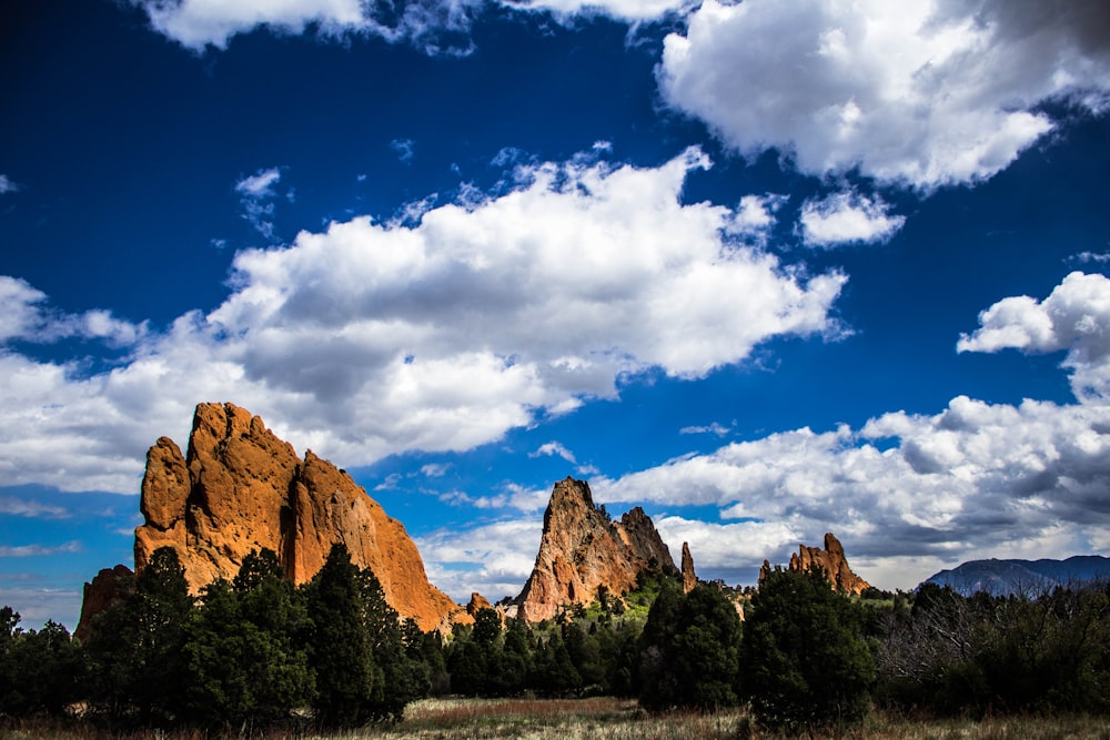 brown rocky mountain under blue sky and white clouds during daytime