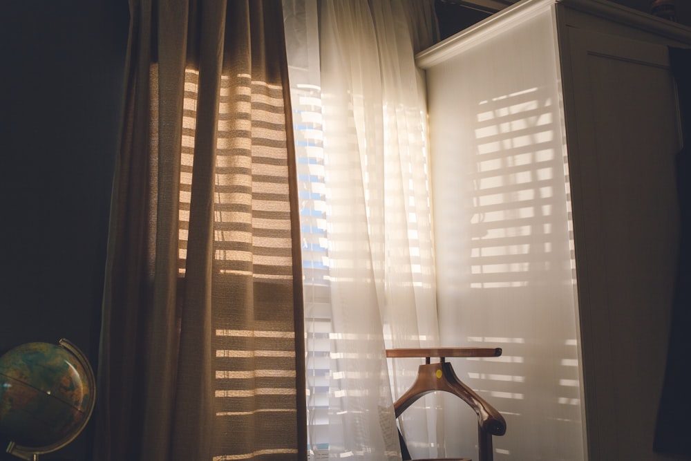 white window curtain near black and brown chair