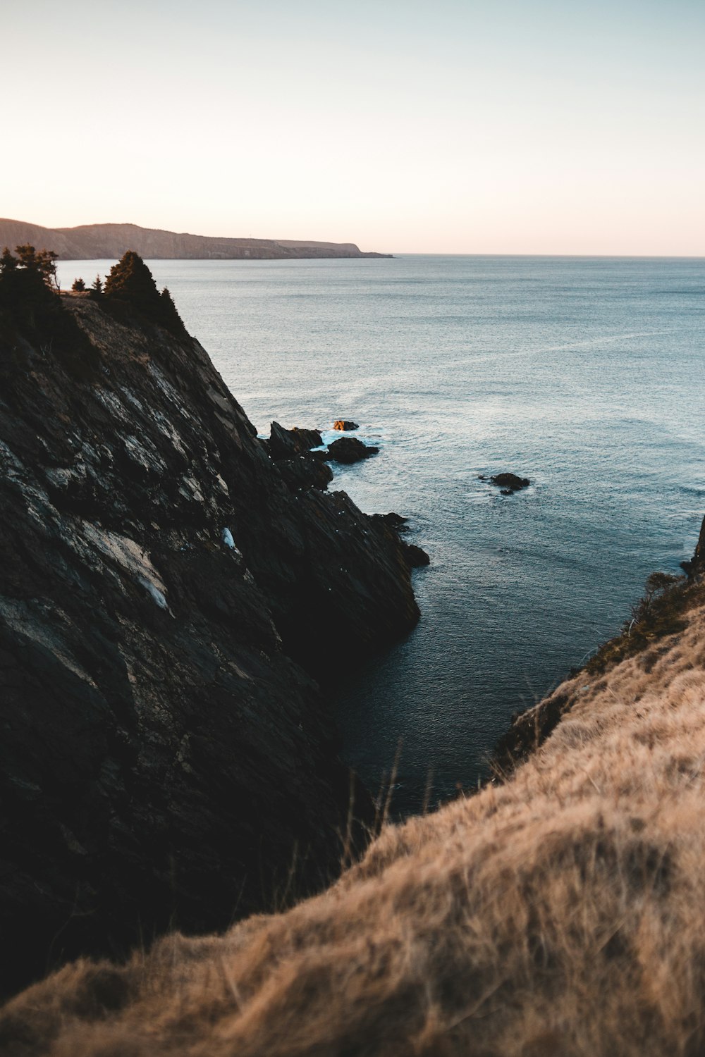 brown rock formation near body of water during daytime