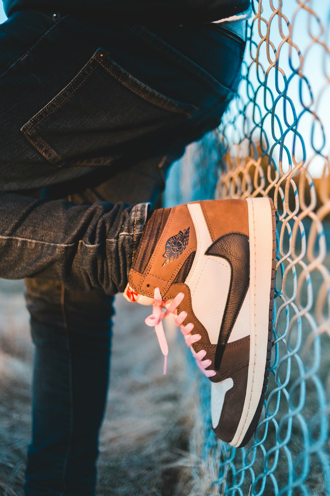 person in blue denim jeans and brown and white nike sneakers