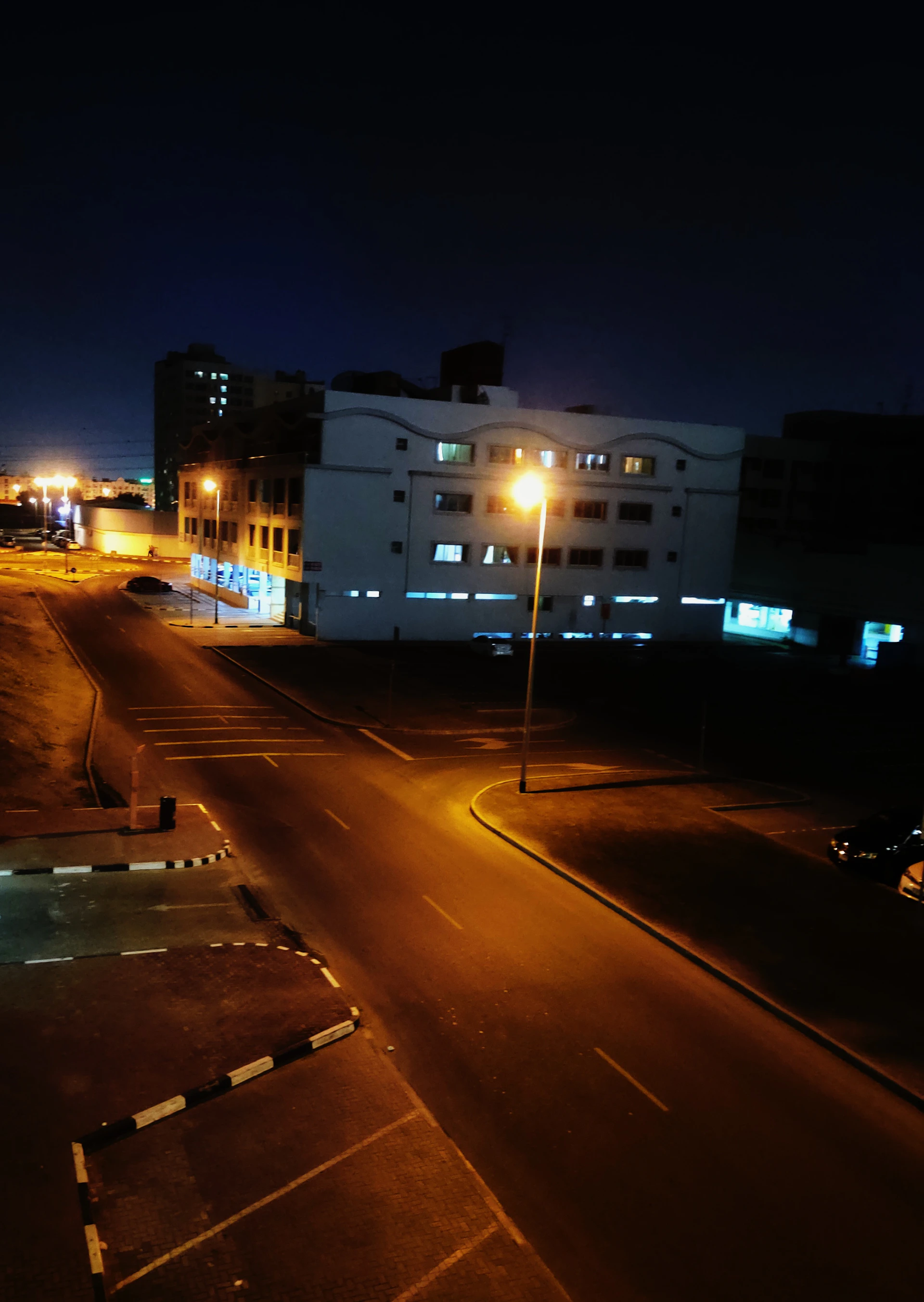 A nighttime cityscape with illuminated surveillance cameras overseeing a quiet street.