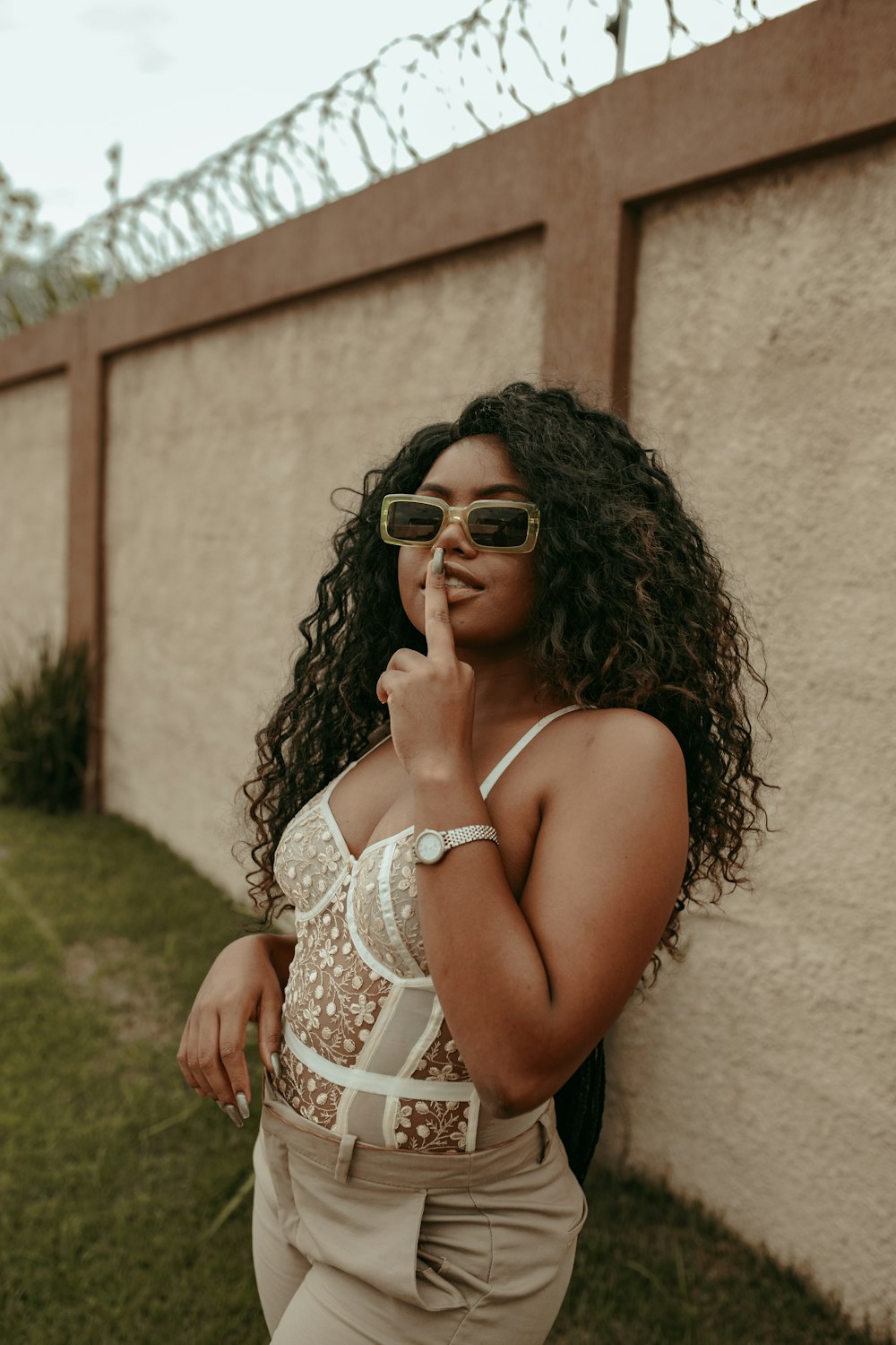 woman in white halter top and white floral skirt wearing sunglasses