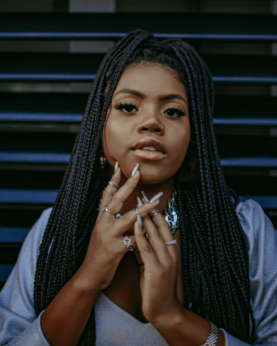 A woman facing the camera with long neat box braids.