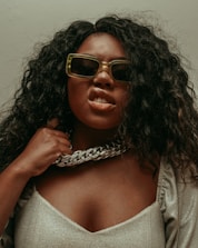 woman in white and black shirt wearing brown framed sunglasses