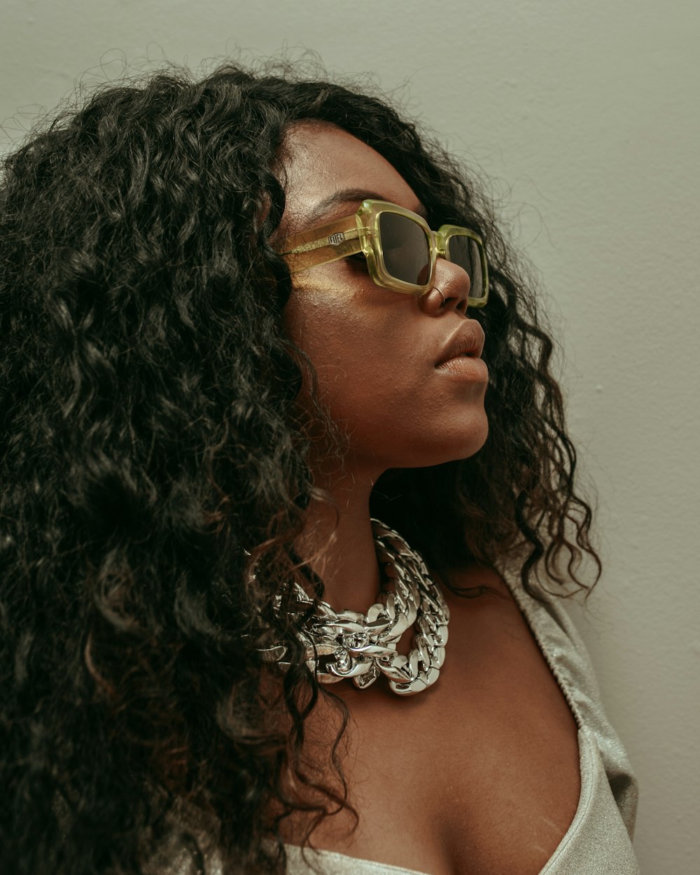 woman in white tank top wearing gold framed sunglasses