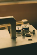 Vintage sewing machine with fabric swatches and spools of thread in soft gold and dusty rose tones.