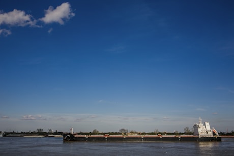 boat on sea under blue sky during daytime