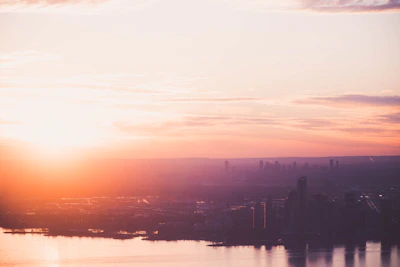 A radiant sunrise casting yellow hues over a city skyline with people greeting each other happily.