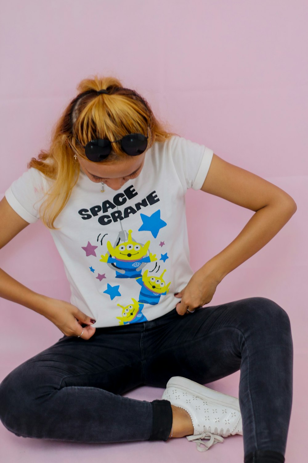 woman in white crew neck t-shirt and blue denim jeans wearing black sunglasses