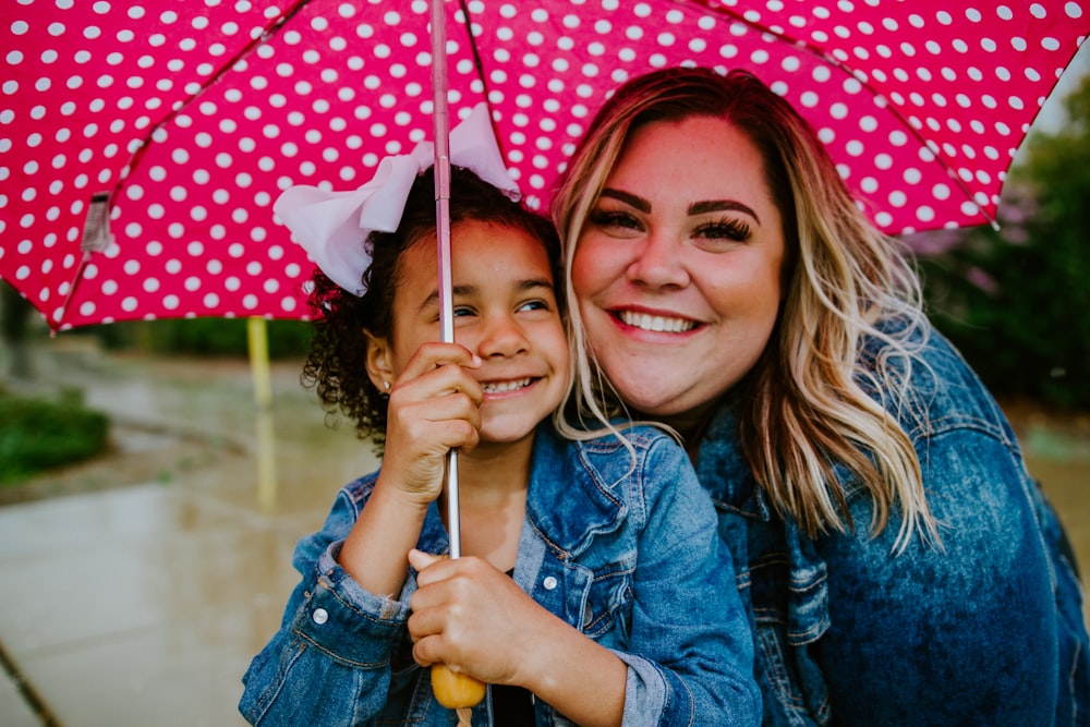 Femme en veste en jean bleue tenant un parapluie souriant