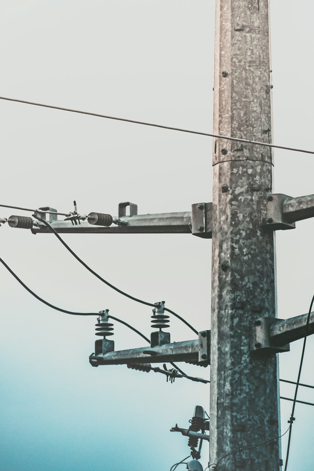 brown electric post under blue sky during daytime