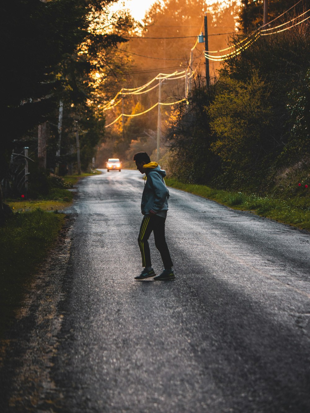 man in black jacket walking on road during daytime