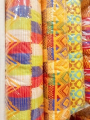 Traditional Indonesian batik fabric rolls in various vibrant patterns.