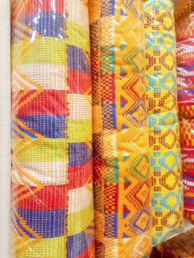 Close-up of vibrant orange and white textile patterns on fabric rolls in a workshop.