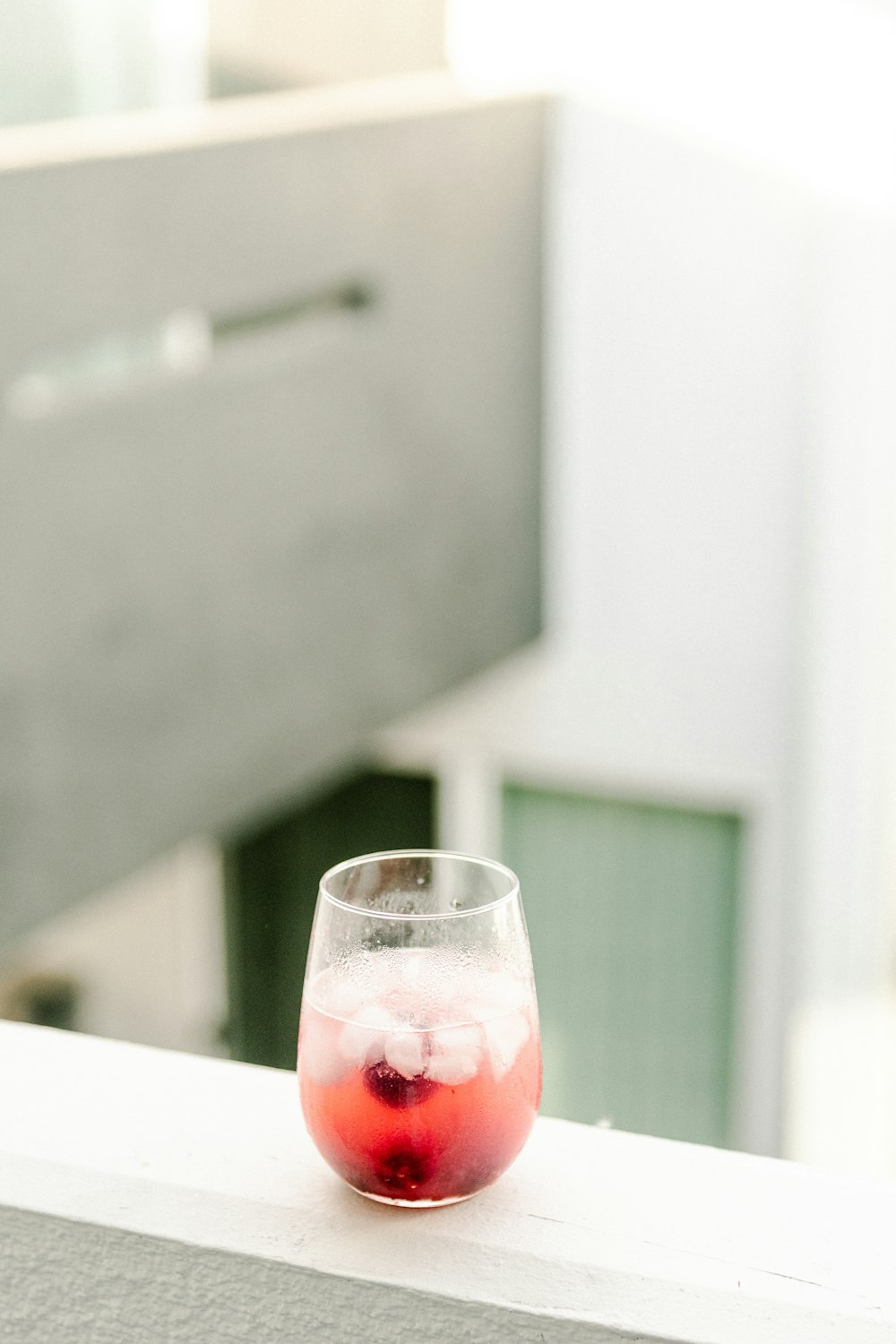 clear drinking glass with red liquid on white table