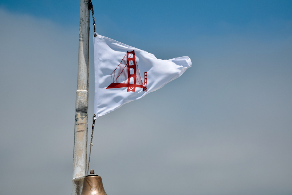 white and red flag on brown pole under blue sky during daytime