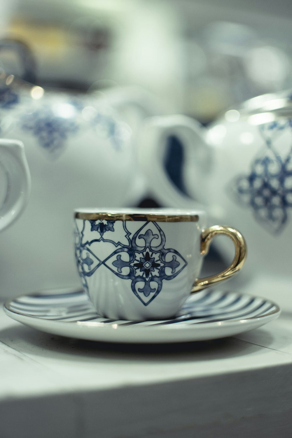 white and blue floral ceramic teacup on saucer