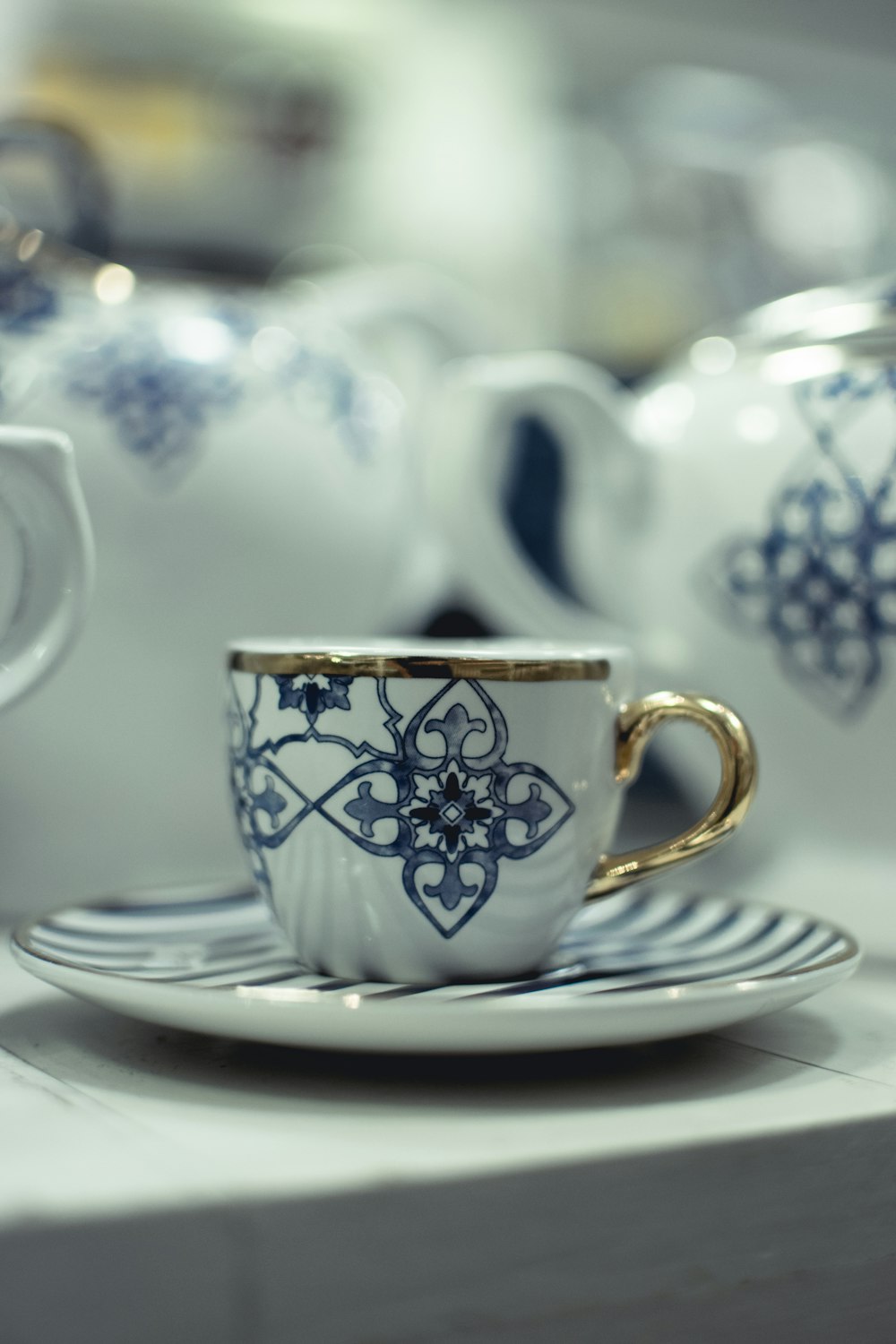xícara de chá de cerâmica floral branca e azul no pires