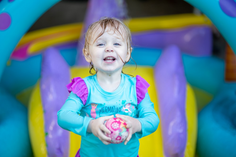 girl in teal long sleeve shirt smiling