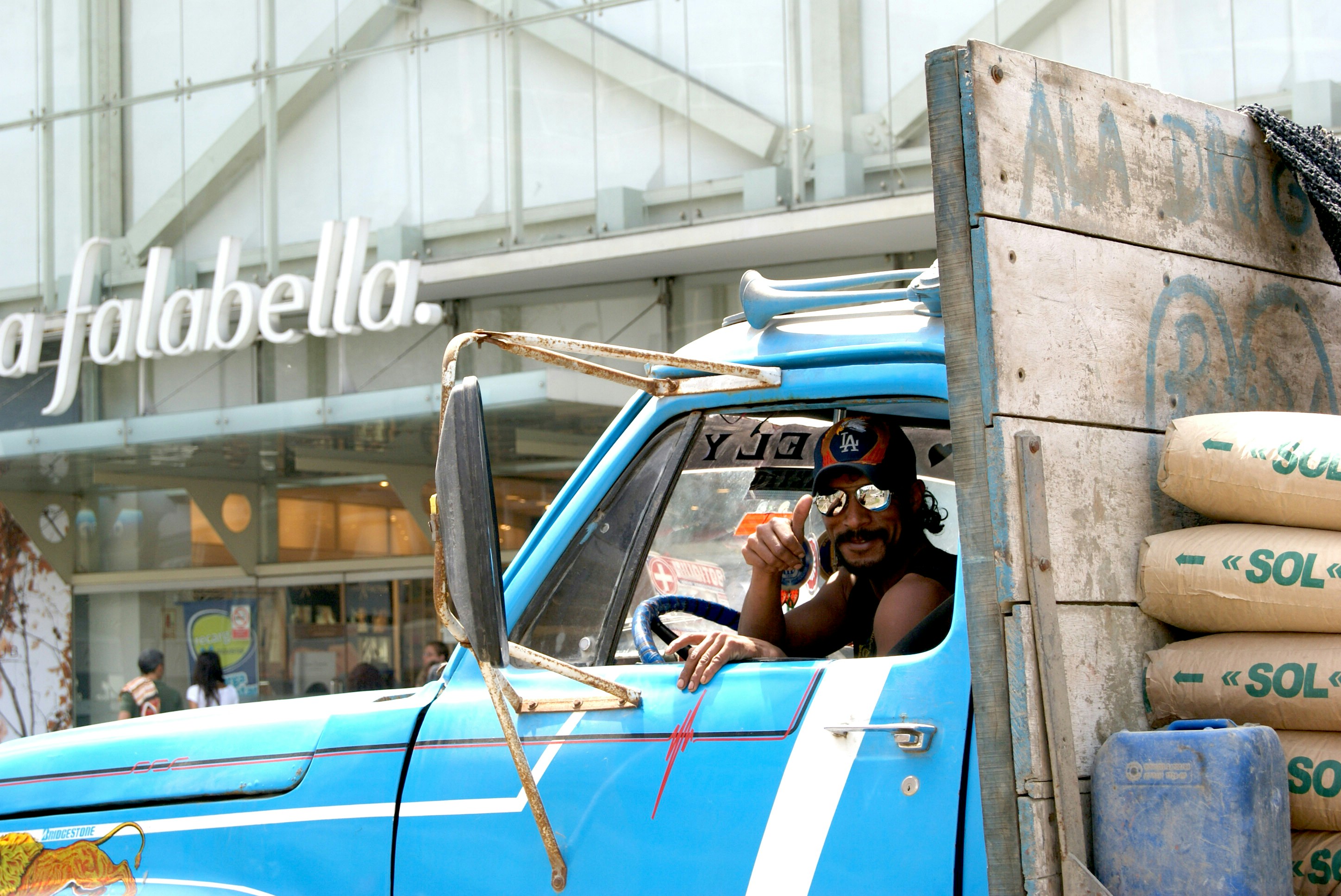 man in black t-shirt sitting on blue car