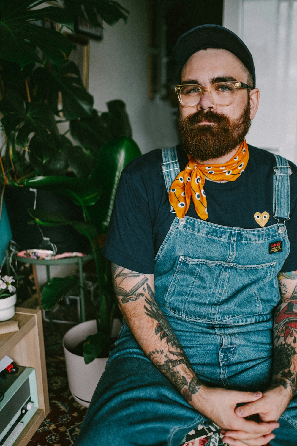 man in blue denim vest and orange and yellow scarf