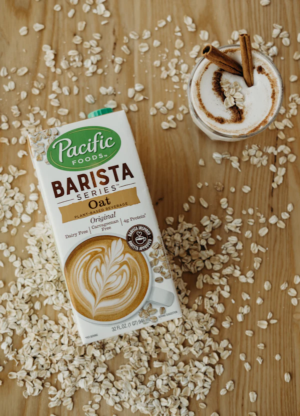 Carton of coconut milk beside a latte