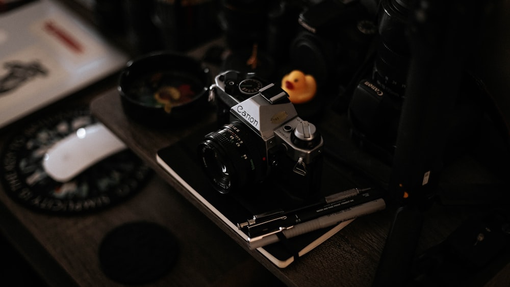 black and silver dslr camera on brown wooden table