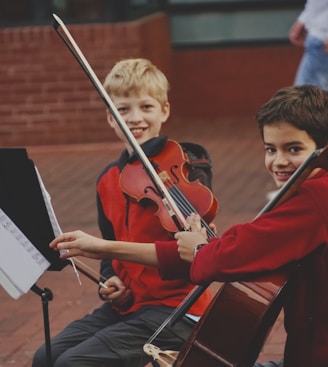 boy in red long sleeve shirt playing violin