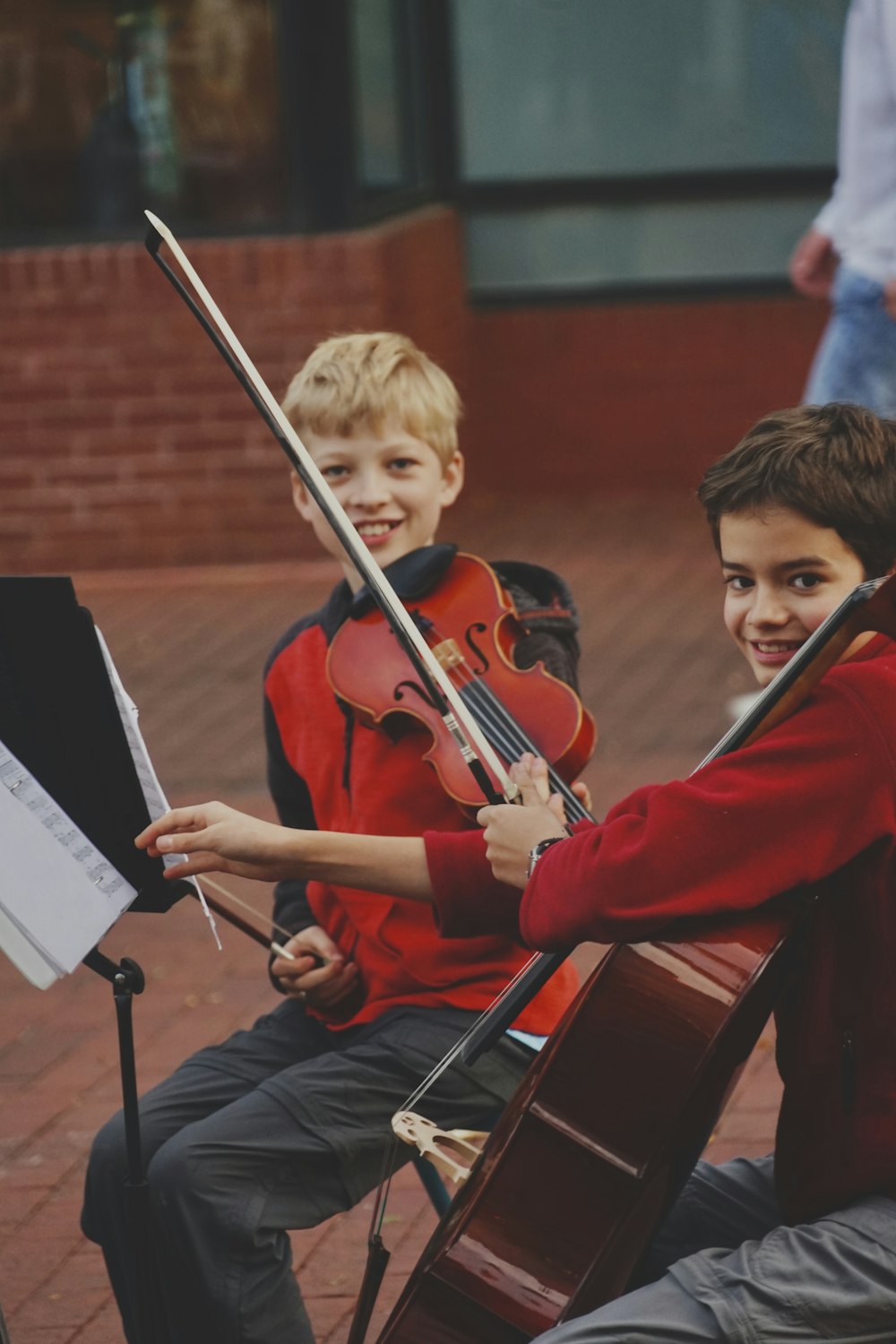 Junge im roten Langarmhemd spielt Geige