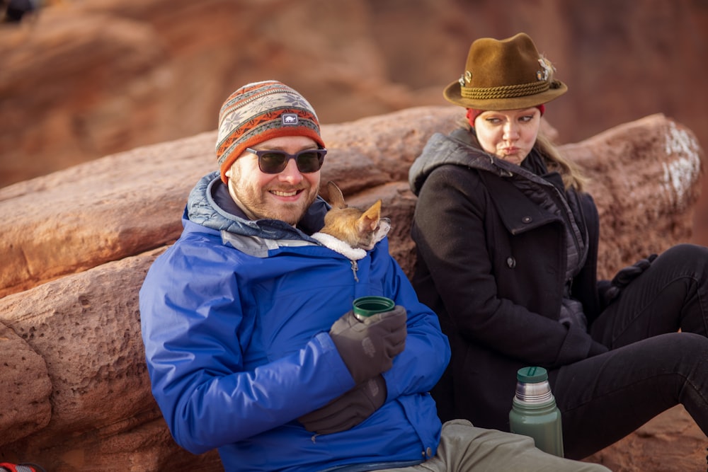 man in black jacket sitting beside woman in blue jacket