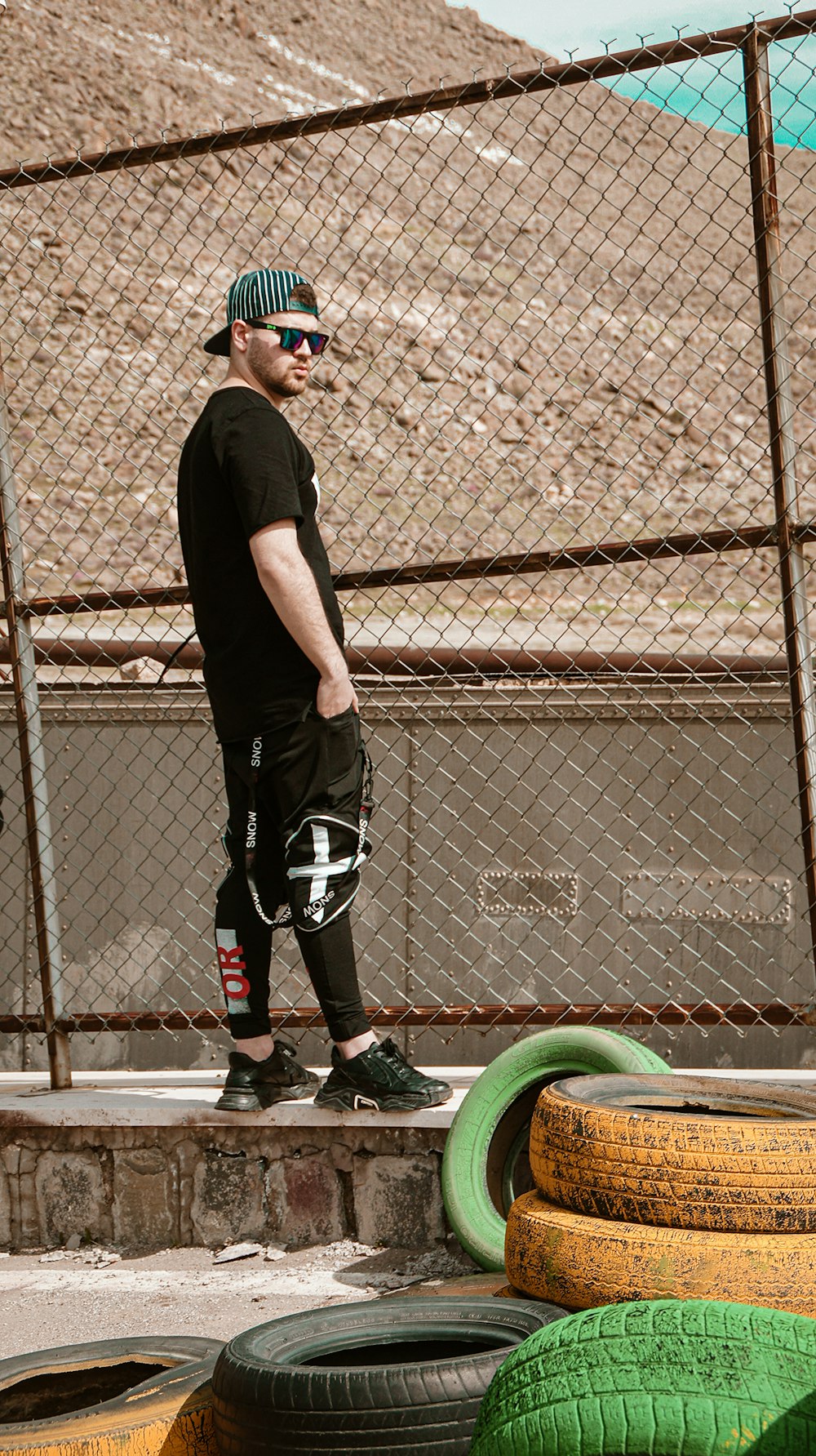 man in black t-shirt and black shorts standing beside green and black bicycle