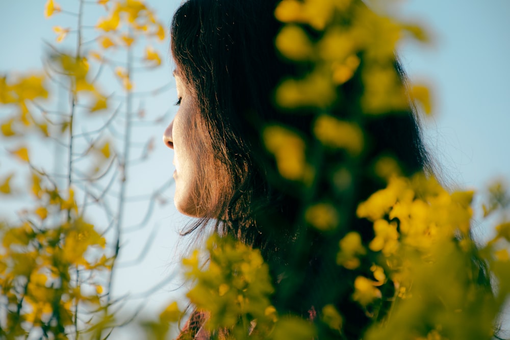 woman looking at yellow flowers