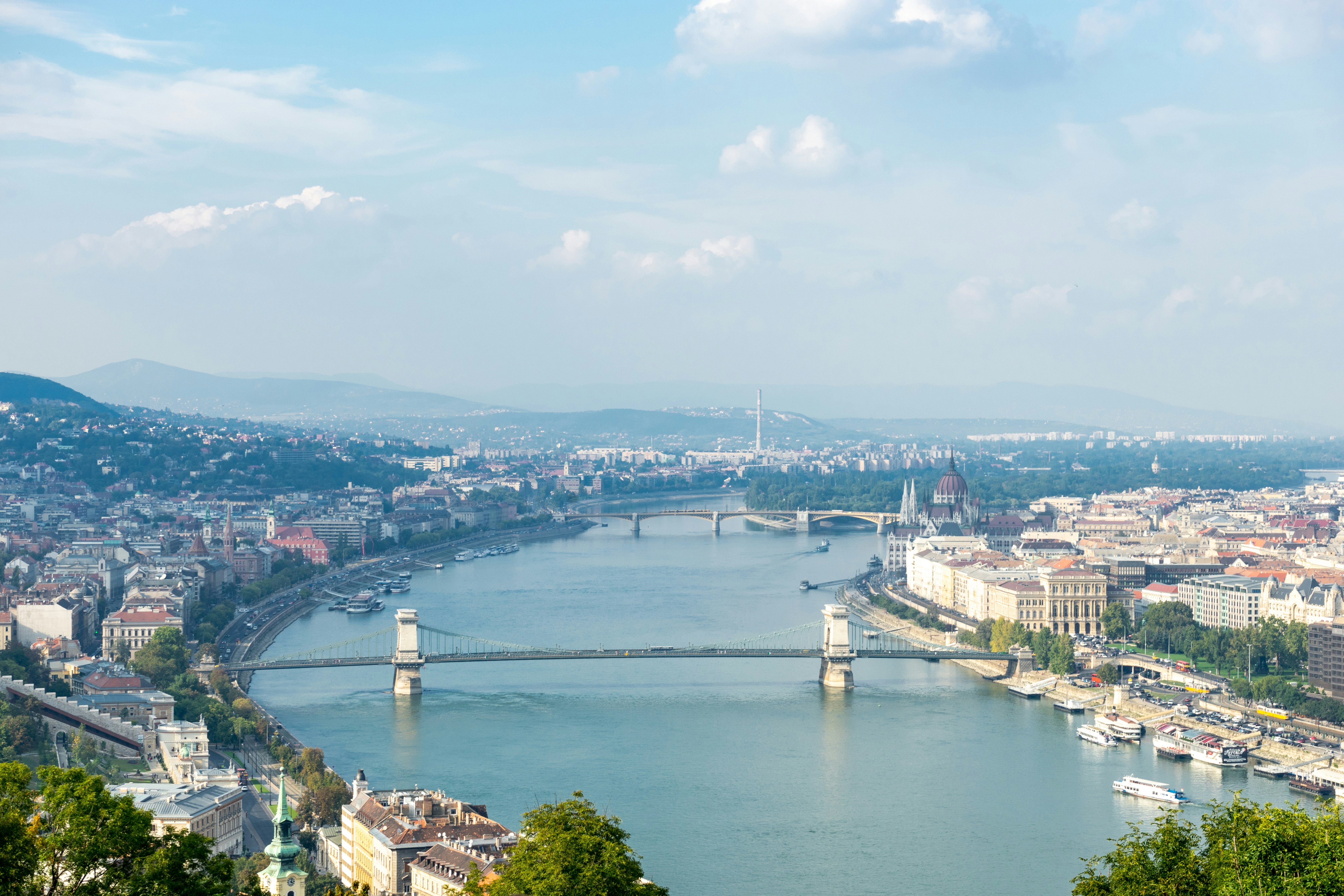aerial view of city buildings near body of water during daytime hungary teams background