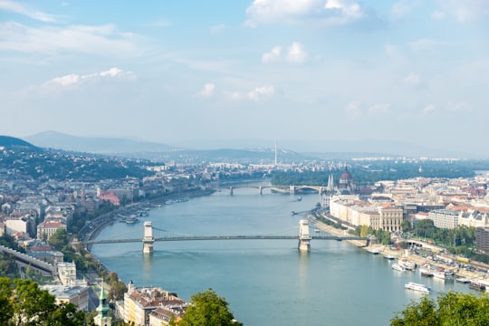 aerial view of city buildings near body of water during daytime in Széchenyi Chain Bridge Hungary