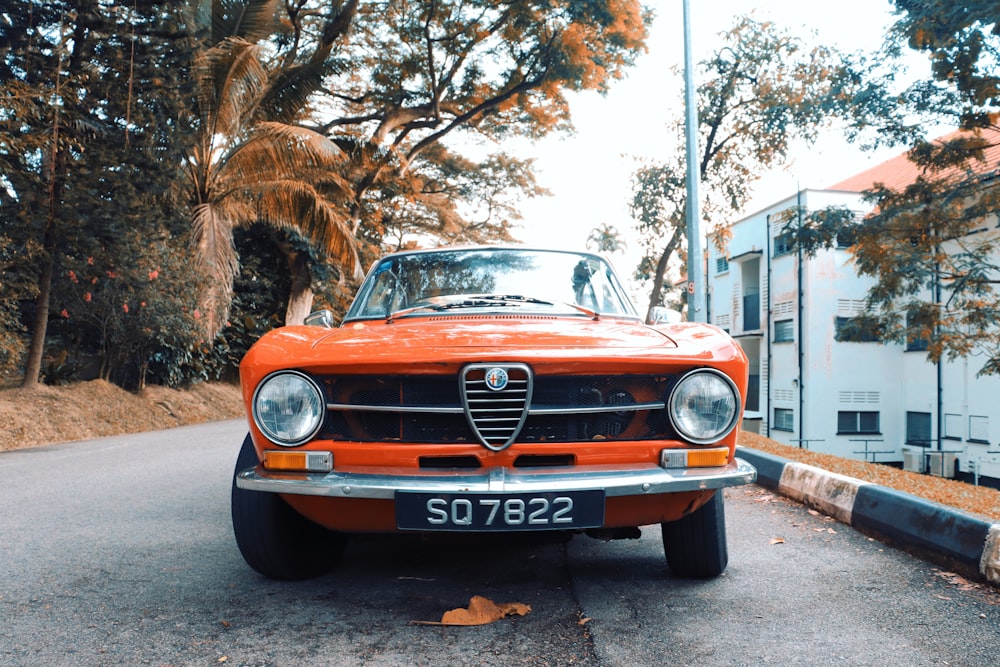 orange bmw car parked on sidewalk during daytime