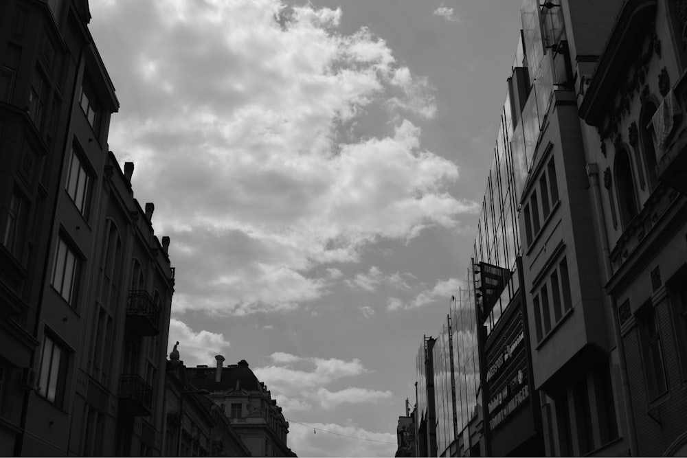 grayscale photo of city buildings under cloudy sky