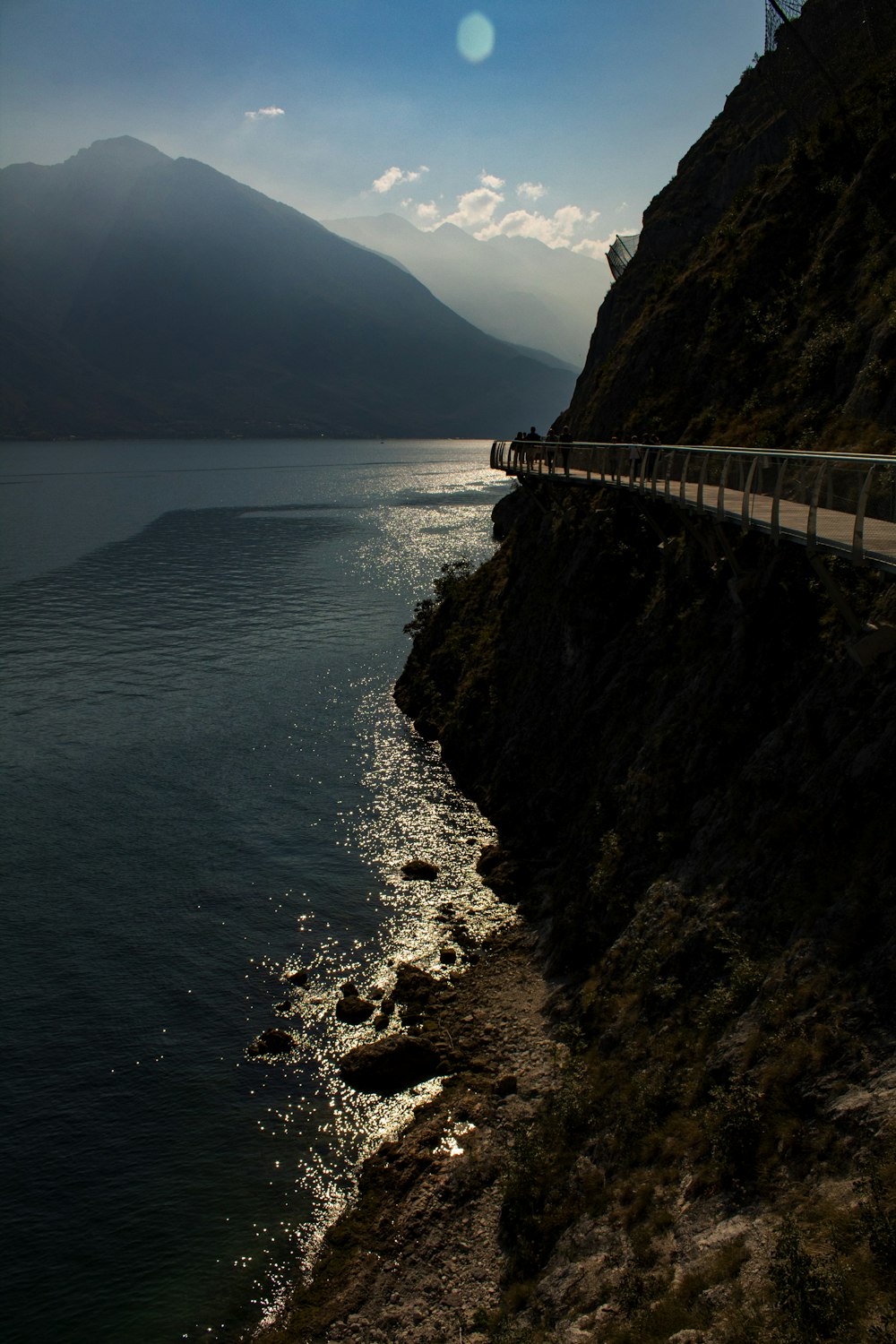 white bridge on body of water near mountain during daytime