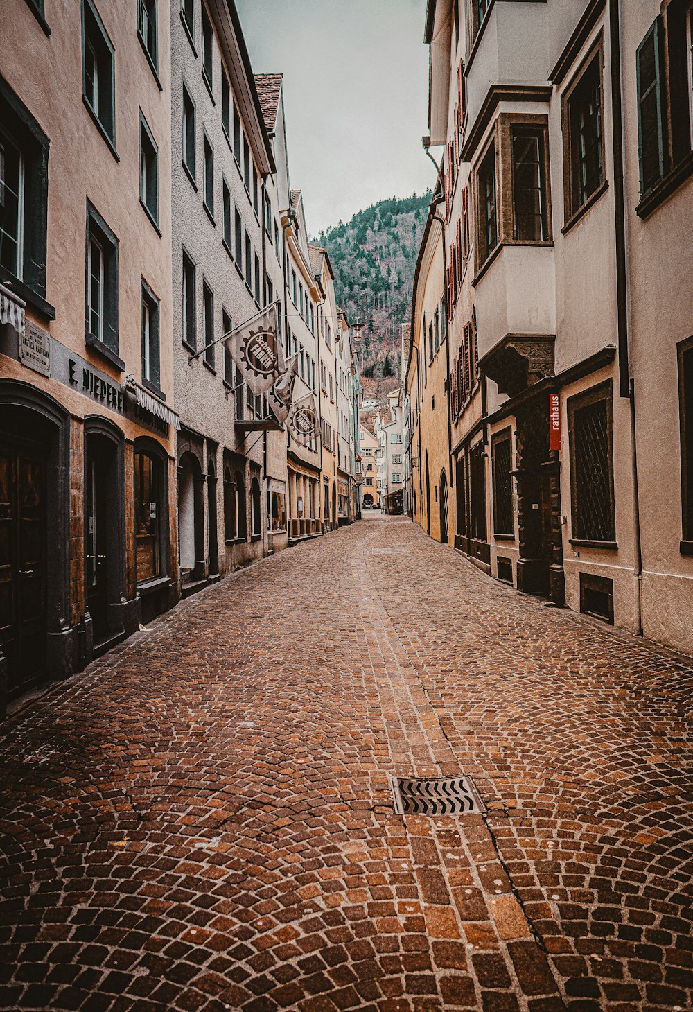 Allée en brique brune entre les bâtiments en béton pendant la journée