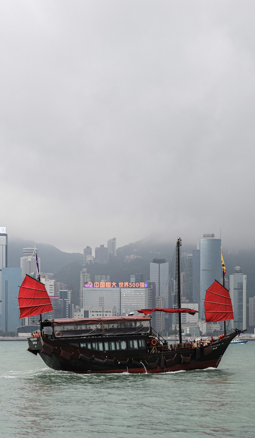 red and white boat on sea near city buildings during daytime