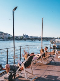 people sitting on chair near body of water during daytime