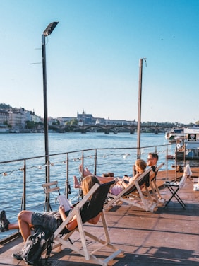 people sitting on chair near body of water during daytime