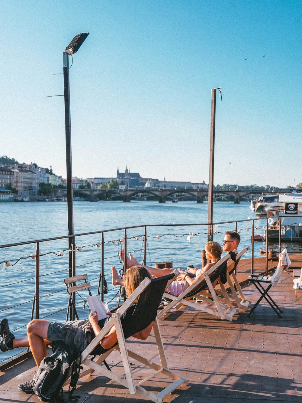 people sitting on chair near body of water during daytime