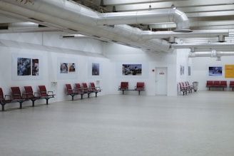 Interior view of Spacio Hangar showing industrial hangar design with minimalist furniture and subtle Italian flag colors.