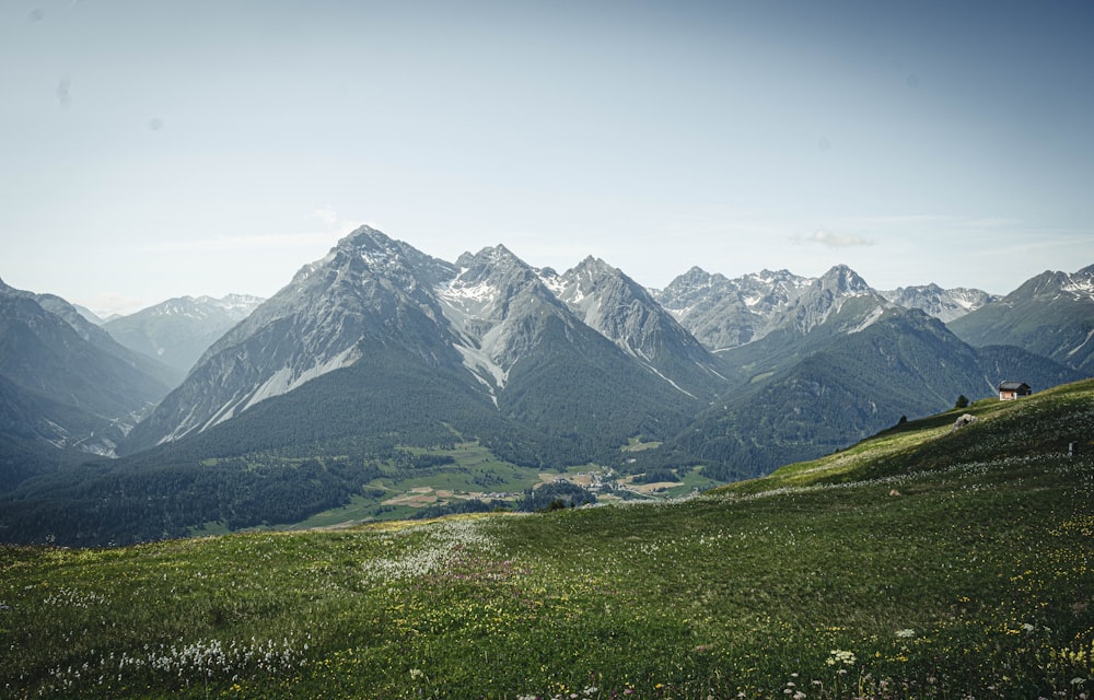 green grass field near snow covered mountain during daytime